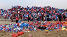 Relawan Nepal dan siswa sekolah membuat replika Laut Mati dari plastik daur ulang di Kathmandu pada 5 Desember 2018. Sebanyak 100.000 kantong plastik diikat di atas kisi besi dengan lebar 20 meter dan tinggi 5 meter. (PRAKASH MATHEMA / AFP)