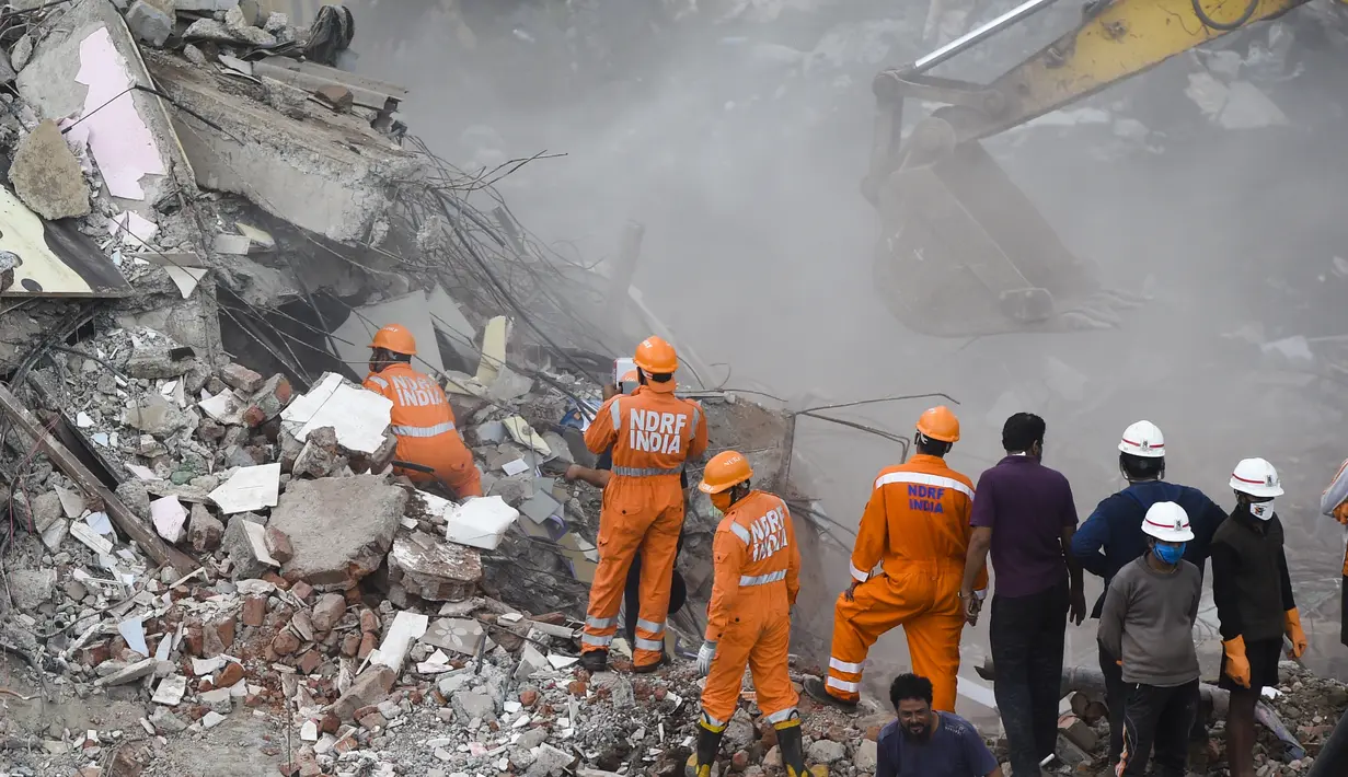 Petugas penyelamat mencari orang-orang di reruntuhan gedung apartemen berlantai lima yang runtuh di Mahad, India (25/8/2020). Polisi menyebut bangunan ini terdiri dari 47 flat. Sekitar 120 kilometer sebelah selatan Mumbai. (AFP Photo/Punit Paranjpe)