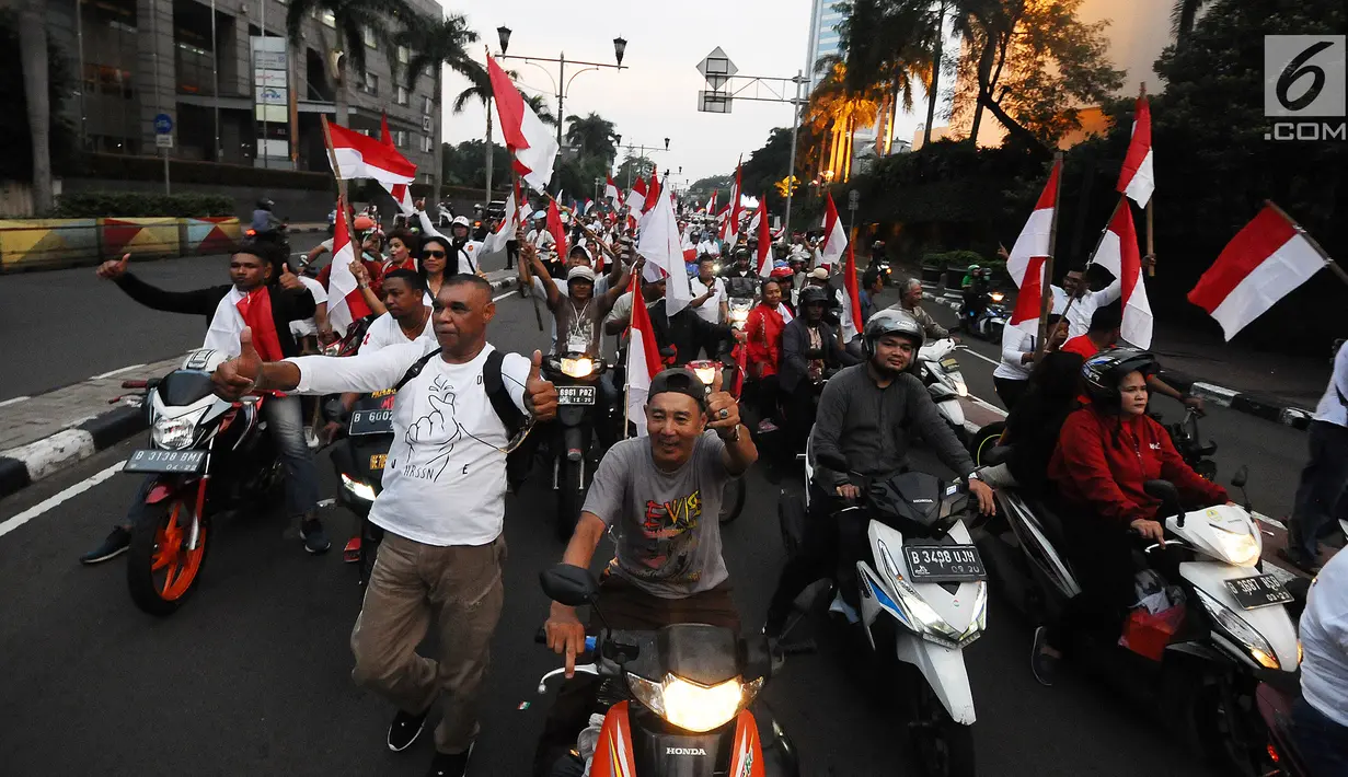 Sejumlah pendukung capres-cawapres 01 Jokowi-Ma'ruf Amin saat arak-arakan di kawasan bunderan HI, Jakarta, Rabu (17/4). Pendukung capres-cawapres 01 arak-arakan merayakan unggul dalam versi hitungan cepat. (Liputan6.com/Herman Zakharia)