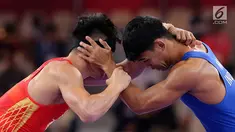 Pegulat putra Indonesia, Muhammad Aliansyah dan Zhang Gaoquan dari China saling mengunci saat bertarung pada kelas putra 67 Kg Asian Games 2018 di arena gulat JCC Senayan, Selasa (21/8). (Liputan6.com/Fery Pradolo)
