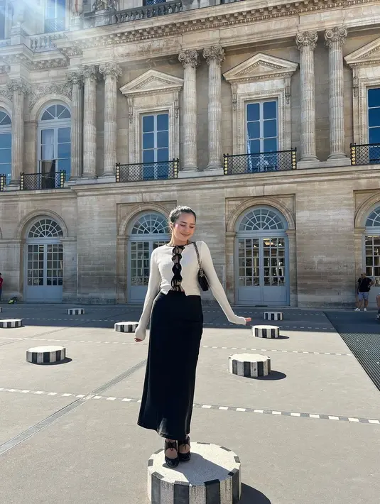 Beby Tsabina juga semakin menawan memamerkan gayanya saat berada di Paris. Ia mengenakan sweater lengan panjang bernuansa broken white dengan aksen tali hitam di bagian tengah, dipadu rok panjang hitam. [Foto: Instagram/bebytsabina]