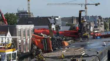 Dua mesin derek jatuh ke rumah warga di Alphen aan den Rijn, Belanda, Senin (3/8/2015) waktu setempat. Dua mesin derek yang sedang memperbaiki jembatan ambruk ke rumah yang ada di dekatnya dan melukai 20 orang. (AFP PHOTO/ANP/LEX VAN LIESHOUT)