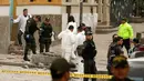 Polisi Kolombia dan ahli forensik memeriksa lokasi ledakan di dekat arena adu banteng Plaza Santamaria di pusat kota Bogota, Minggu (19/2). Ledakan juga turut mengancurkan jendela sejumlah gedung apartemen di dekat lokasi. (AP Photo/Ricardo Mazalan)