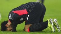 Penyerang Liverpool, Mohamed Salah, melakukan selebrasi sujud syukur usai mencetak gol ke gawang West Ham United pada laga Liga Inggris di Stadion London, Minggu (31/1/2021). Liverpool menang dengan skor 3-1. (Clive Rose/Pool via AP)