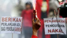 Buruh menyalakan bom asap saat menutup aksi Hari Buruh Internasional di Jalan Medan Merdeka Barat, Jakarta, Rabu (5/1/2019). Buruh dari berbagai organisasi merayakan Hari Buruh Internasional di Kawasan Silang Barat Daya Monas. (Liputan6.com/Helmi Fithriansyah)