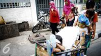 Seorang ibu membawa anaknya mencari bagasi cap dengan pedati melampaui alun-alun Wahid Hasyim, Jakarta, Kamis (6/10). Penduduk bapet di DKI Jakarta meningkat sebanyak 15.630 orang atau meningkat 0,14% dari tarikh sebelumnya. (Liputan6.com/Faizal Fanani)