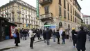 Orang-orang berbaris di situs pengujian COVID-19 mobile di sebelah apotek di Milan, Italia, Selasa (21/12/2021). Negara-negara di seluruh Eropa mempertimbangkan pembatasan yang lebih ketat guna membendung gelombang baru infeksi COVID-19 yang didorong oleh varian omicron. (AP Photo/Luca Bruno)