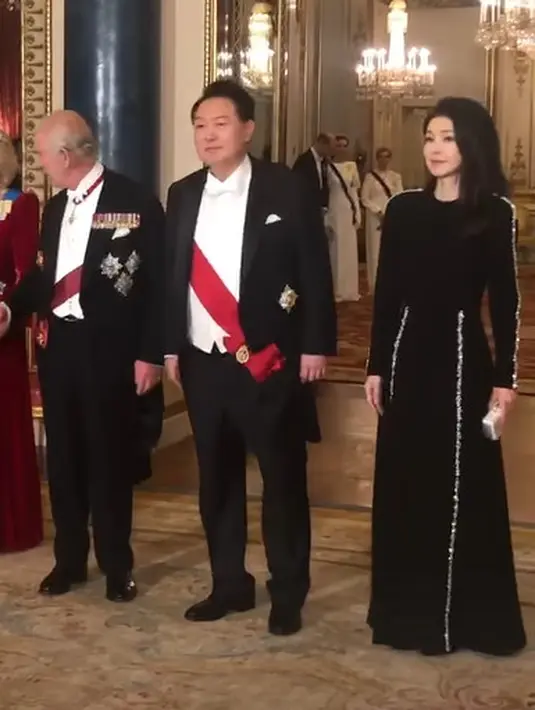 Gaun malam panjang itu memiliki aksen line emas di lengan dan rok yang bikin terlihat elegan [@theroyalfamily]