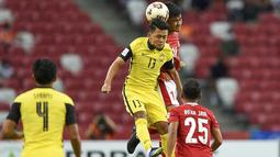 Bek Timnas Indonesia, Asnawi Mangkualam, berduel dengan pemain Malaysia, Arif Rahman, pada laga penyisihan Grup B Piala AFF 2020.(AFP/Roslan Rahman)