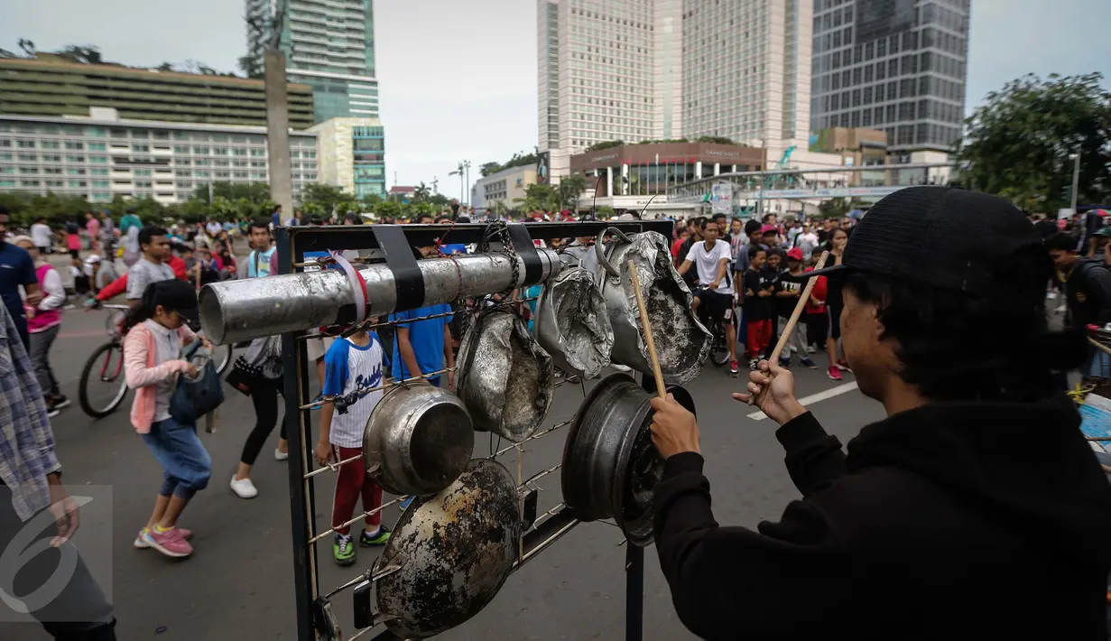 Kreatifitas mahasiswa dalam bermusik dengan alat musik dari barang bekas sangat menghibur warga yang beraktifitas di Car Free Day Bundaran HI, Jakarta, Minggu (15/1). (Liputan6.com/Faizal Fanani)