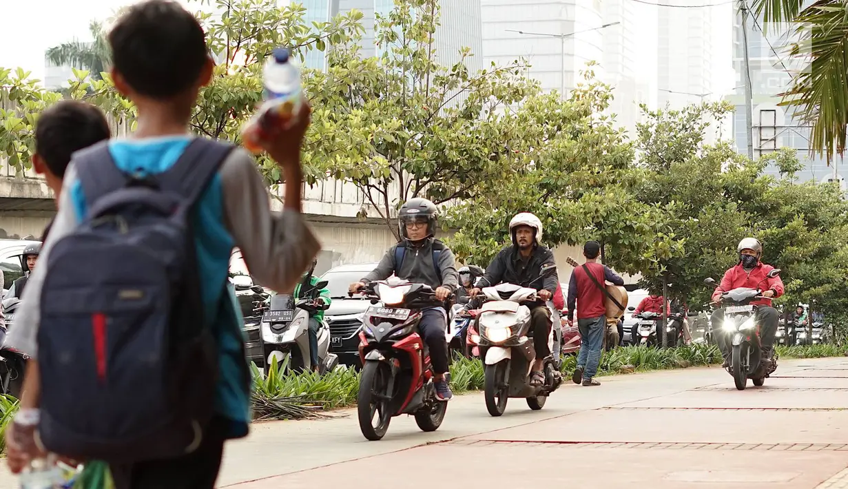 Pengendara sepeda motor melintasi trotoar di kawasan Menteng Pulo, Jakarta, Selasa (14/5/2019). Kemacetan yang semakin parah di Ibu Kota menyebabkan para pemotor nekat menerobos trotoar dan merampas hak pejalan kaki. (Liputan6.com/Immanuel Antonius)