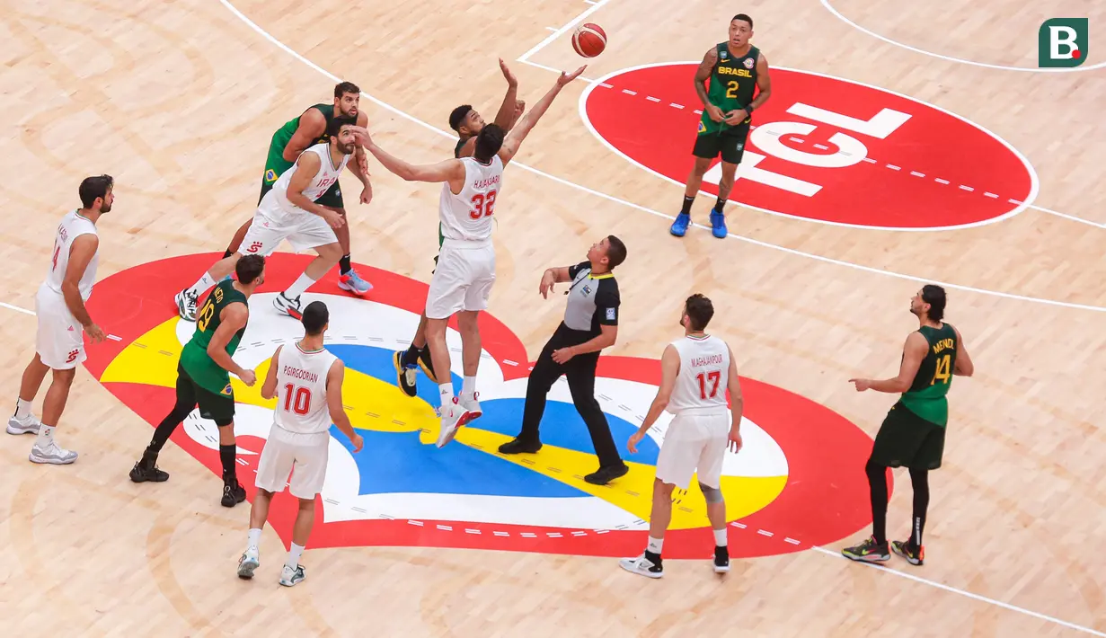 Pebasket Iran, Hasan Aliakbari (tengah kanan) berebut bola dengan pebasket Brasil, Bruno Caboclo (tengah kiri) saat melakukan tip off pada laga Grup G Piala Dunia FIBA 2023 antara Iran melawan Brasil di Indonesia Arena, Senayan, Jakarta, Sabtu (26/08/2023). (Bola.com/Bagaskara Lazuardi)