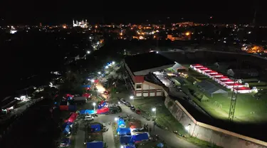 Foto udara menunjukkan tenda-tenda di tempat penampungan darurat di Mamuju (19/1/2021). Tempat pengungsian ini dibangun untuk orang-orang yang terdampak gempa berkekuatan 6,2 yang mengguncang pulau Sulawesi pada 15 Januari 2021. (AFP/Adek Berry)