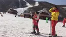 Seorang ibu dan putrinya beristirahat di lereng di resor ski Masik Pass di Korea Utara (28/1). Resor ski ini juga sebagai tempat latihan tim ski Korea Utara dan Korea Selatan menjelang Olimpiade Pyeongchang 2018. (AP Photo / Eric Talmadge)