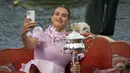 Petenis Belarusia, Aryna Sabalenka berselfie dengan trofi kejuaraan tenis Australia Open 2023 di atas gondola di Royal Botanic Garden di Melbourne (29/1/2023). Sabalenka menjadi petenis Belarusia kedua yang memenangi Australia Open setelah Victoria Azarenka pada 2012 dan 2013. (AP Photo/Dita Alangkara)