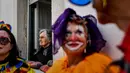Seorang wanita lansia mengamati orang-orang yang bersuka ria ikut serta dalam parade badut tahunan di Sesimbra, Portugal pada Senin (4/3/2019). Perayaan ini dilakukan setiap tahun dan jatuh pada hari Senin. (PATRICIA DE MELO MOREIRA / AFP)