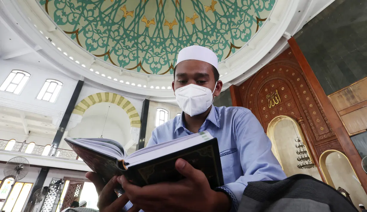 Seorang siswa mengenakan masker untuk membantu mengekang penyebaran COVID-19 saat membaca kitab suci Alquran di Masjid Attaqwa, Bekasi, Jawa Barat, Selasa (4/5/2021). Selama Ramadhan, umat muslim menahan diri dari makan, minum, merokok dan seks dari subuh hingga maghrib. (AP Photo/Achmad Ibrahim)