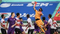 Kiper Madura United, Muhammad Ridho (atas) berusaha menghalau bola saat melawan Persik Kediri dalam laga pekan ke-13 BRI Liga 1 2021/2022 di Stadion Moch. Soebroto, Magelang, Rabu (24/11/2021). (Bola.com/Bagaskara Lazuardi)