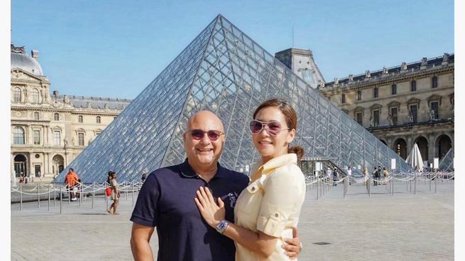 Irwan Mussry dan Maia Estianty pose di depan Museum Louvre, Prancis. (dok. Instagram @maiaestiantyreal/https://www.instagram.com/p/BzPgf27HZBo/Putu Elmira)