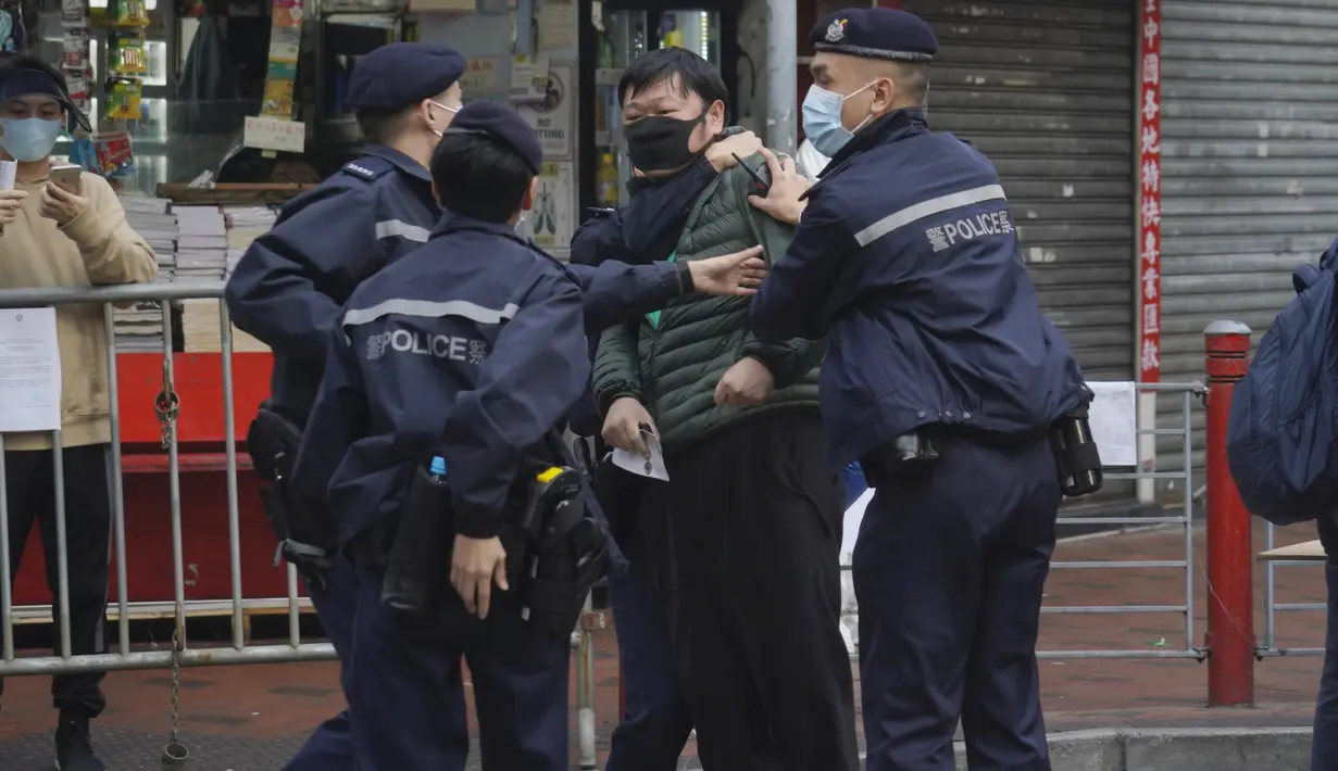 Seorang pria ditahan setelah menyerang petugas polisi saat ingin memasuki area tertutup di daerah Yordania di Hong Kong, Sabtu (23/1/2021). Penguncian diberlakuan setelah pihak berwenang memerangi wabah di salah satu distrik termiskin dan paling padat di kota itu. (AP Photo/Kin Cheung)