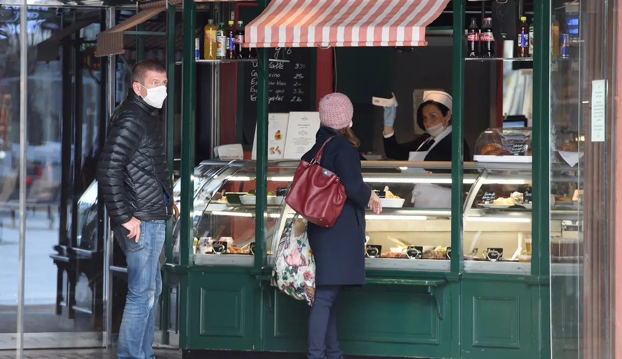 Sejumlah pelanggan mengunjungi gerai makanan ringan yang dibuka kembali di jalan Graben di Wina, Austria, (14/4/2020). Beberapa toko dan bisnis di Austria mulai dibuka kembali sejak Selasa (14/4). (Xinhua/Guo Chen)