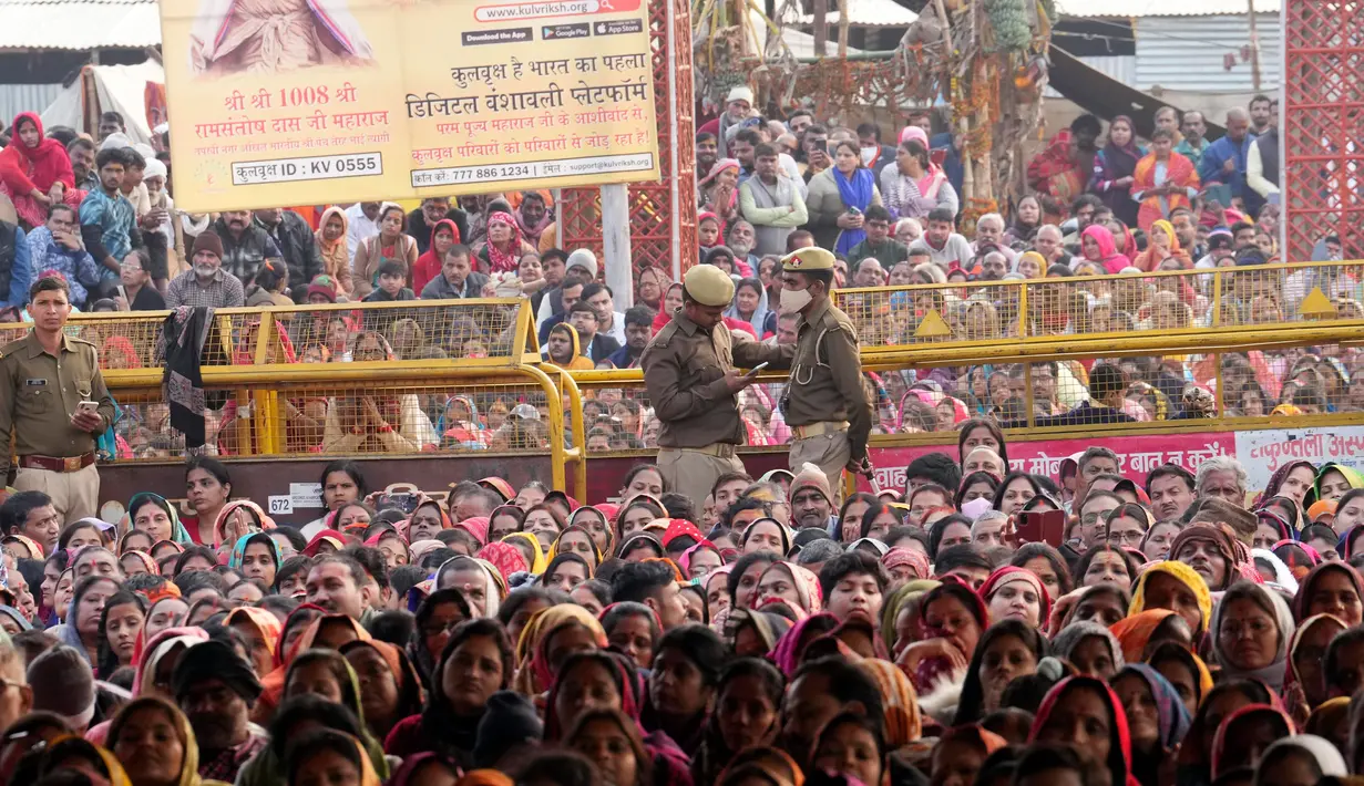 Umat Hindu mendengarkan seorang pemimpin agama saat Festival Magh Mela di Sangam, pertemuan Sungai Gangga - Sungai Yamuna, Prayagraj, Uttar Pradesh, India, 31 Januari 2023. Ratusan ribu peziarah Hindu diperkirakan akan berenang dalam pertemuan tersebut, berharap bisa menghapus dosa selama festival sebulan penuh. (AP Photo/Rajesh Kumar Singh)