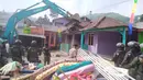 Pekerja mengoperasikan alat berat disaksikan personel gabungan saat pembongkaran bangunan di Kampung Naringgul, Kab. Bogor, Kamis (29/8/2019). Pembongkaran bangunan yang kerap digunakan sebagai penginapan jam-jaman hingga tempat mesum itu melibatkan 500 persenel gabungan. (Liputan6.com/Alby Azka)