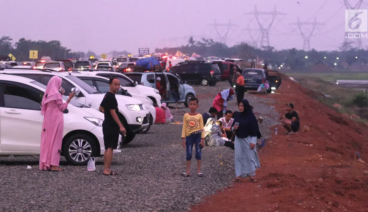 Pemudik beristirahat sambil berbuka puasa di pinggir Tol Fungsional Pemalang-Batang, Jawa Tengah, Minggu (10/6). Mereka memanfaatkan waktu istirahat di pinggir tol yang belum rampung dibangun. (Liputan6.com/Arya Manggala)