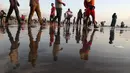 Orang-orang berjalan di Pantai Juhu, Mumbai, India, Selasa (24/8/2021). India mencatat penambahan 14.419 kasus positif COVID-19 pada 24 Agustus 2021. (AP Photo/Rafiq Maqbool)