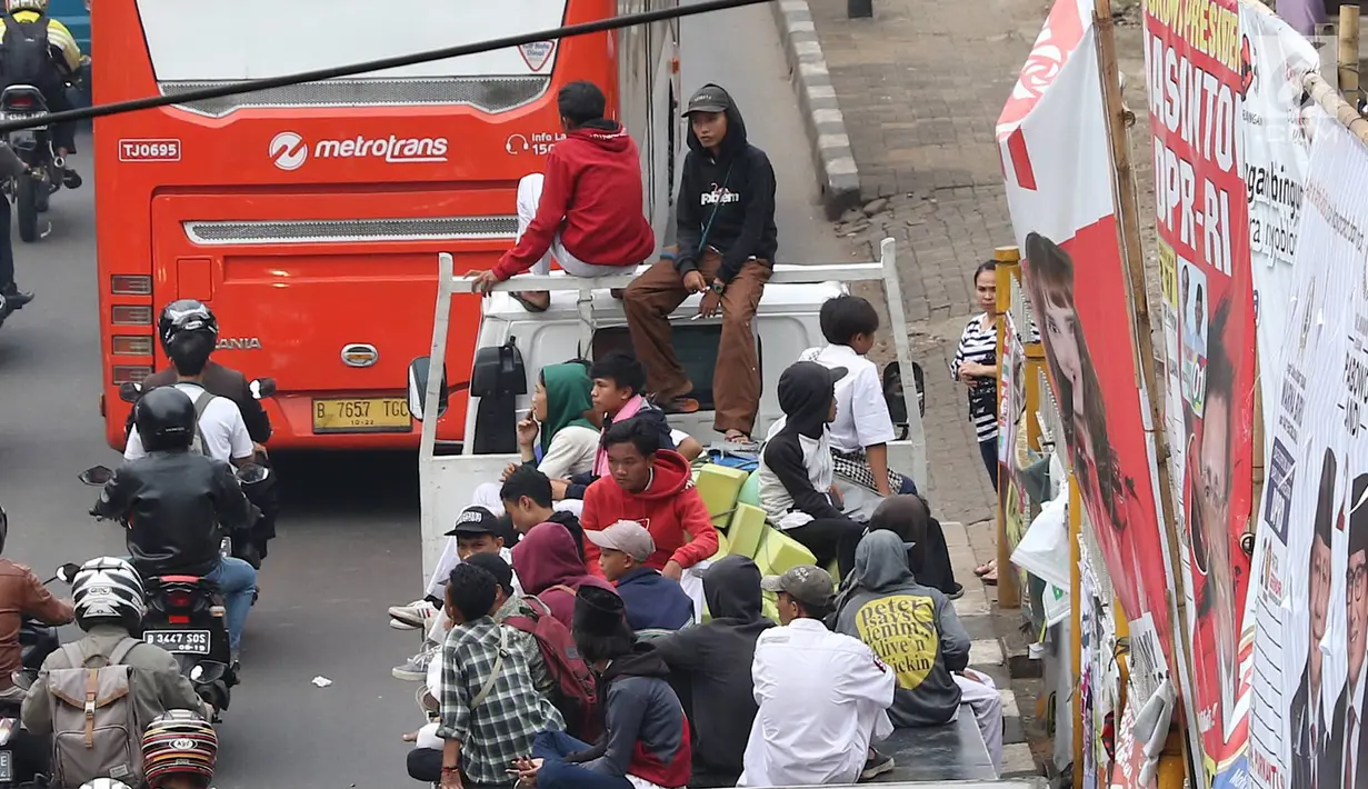 Pelajar menumpang truk terbuka yang melintas di kawasan Lenteng Agung, Jakarta, Senin (8/4). Perilaku buruk tersebut membahayakan keselamatan diri mereka dan pengguna jalan lain. (Liputan6.com/Immanuel Antonius)