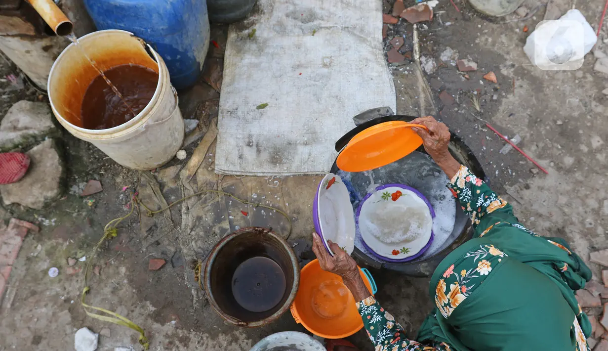 Warga memanfaatkan air yang menghitam di Desa Sukaringin, Sukawangi, Kabupaten Bekasi, Jawa Barat, Jumat (10/9/2021). Menurut warga, saat musim kemarau kualitas air tanah berwarna hitam dan sudah berlangsung selama delapan bulan. (Liputan6.com/Herman Zakharia)