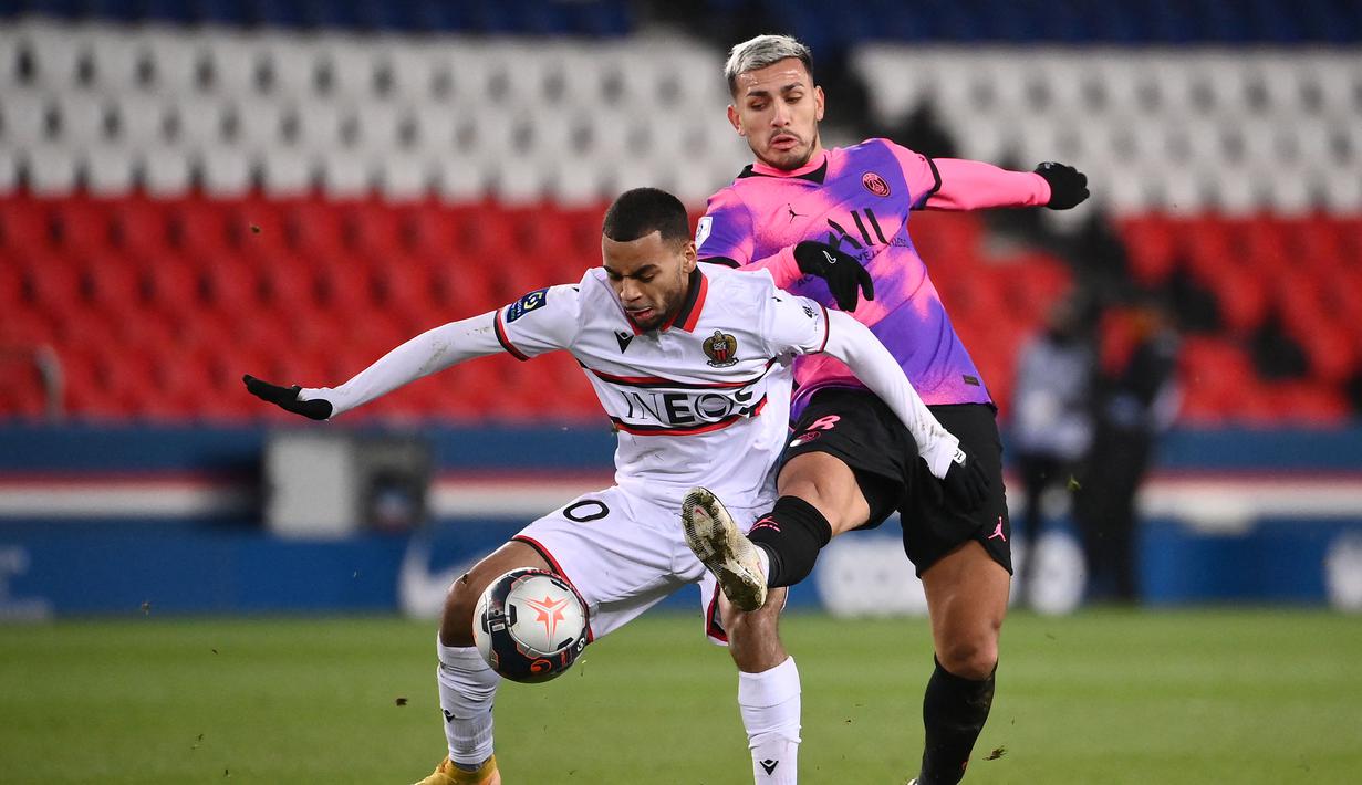 Striker OGC Nice, Alexis Claude-Maurice (kiri) berebut bola dengan gelandang Paris Saint-Germain, Leandro Paredes dalam laga lanjutan Liga Prancis 2020/21 pekan ke-25 di Parc des Princes Stadium, Paris, Sabtu (13/2/2021). Nice kalah 1-2 dari Paris Saint-Germain. (AFP/Franck Fife)