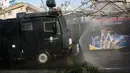 Kendaraan Water Canon kepolisian menyempotkan desinfektan untuk mensterilkan jalan-jalan di Teheran, 1 Maret 2020. Kasus virus corona di Iran mengalami lonjakan tajam dalam beberapa hari dan tercatat memiliki korban meninggal tertinggi setelah China, yang menjadi pusat wabah. (AP Photo/Vahid Salemi)