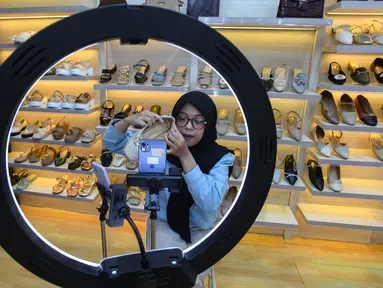 Pekerja memasarkan produk secara online produk sepatu sandal yang akan di bengkel kerja Patris di kawasan Katulampa, Bogor, Senin, 24 Agustus 2026. (KLY/ Arie Basuki)