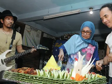 Kaka Slank mendapat potongan tumpeng dari Bunda Iffet saat merayakan ulang tahun di di Potlot, Jakarta Selatan, Jumat (10/3). Tahun 2017 ini, usai Kaka telah mencapai 43 tahun. (Liputan6.com/Herman Zakharia)