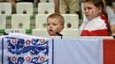 Dua suporter cilik asal Inggris tengah serius mnyaksikan laga timnya melawan Slovakia pada piala Eropa 2016 di Stadion Geoffroy-Guichard, Saint-Etienne,(20/6/2016). (AFP/Jeff Pachoud)
