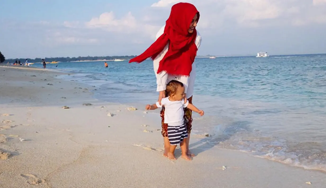 Shireen dan Adam tidak mau melewatkan kesempatan untuk menikmati indahnya pasir putih. (via Instagram)