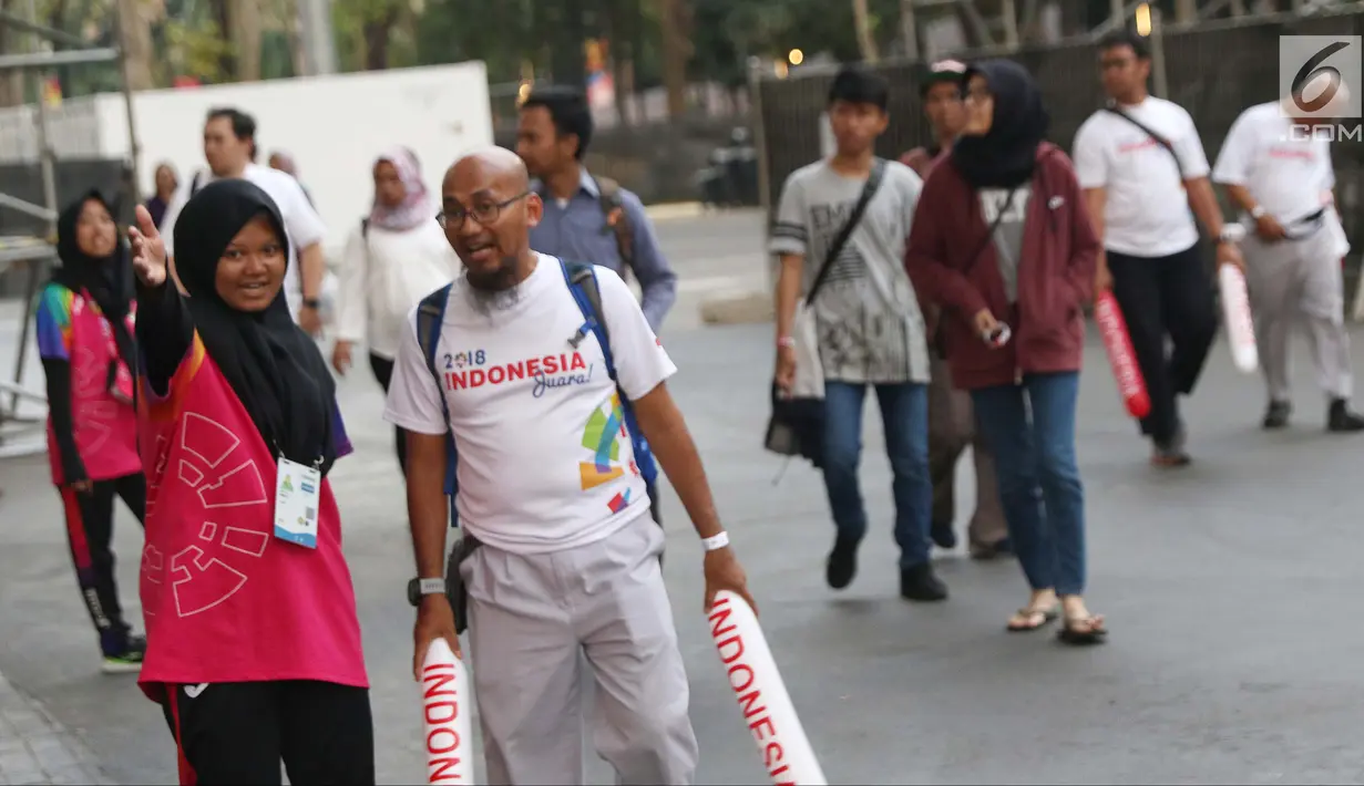 Volunteer Asian Para Games 2018 membantu suporter menunjukkan lokasi pintu masuk di Stadion GBK, Jakarta, Kamis (11/10). Mereka bertugas membantu kelancaran pelaksanaan Asian Para Games 2018. (Liputan6.com/Helmi Fithriansyah)