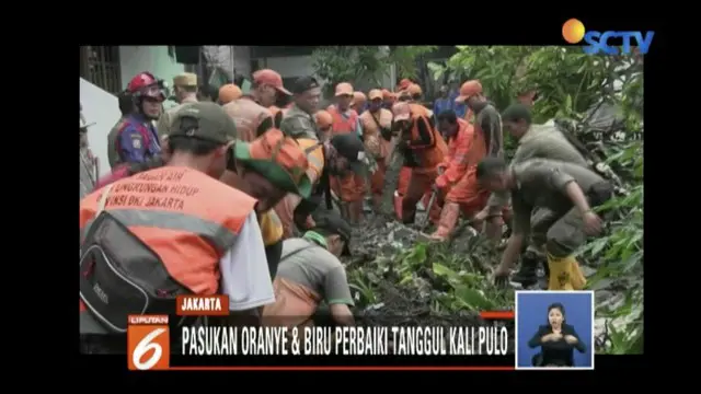 Pasukan Oranye dan biru perbaiki tanggul Kali Pulo yang jebol pada Minggu (13/1).