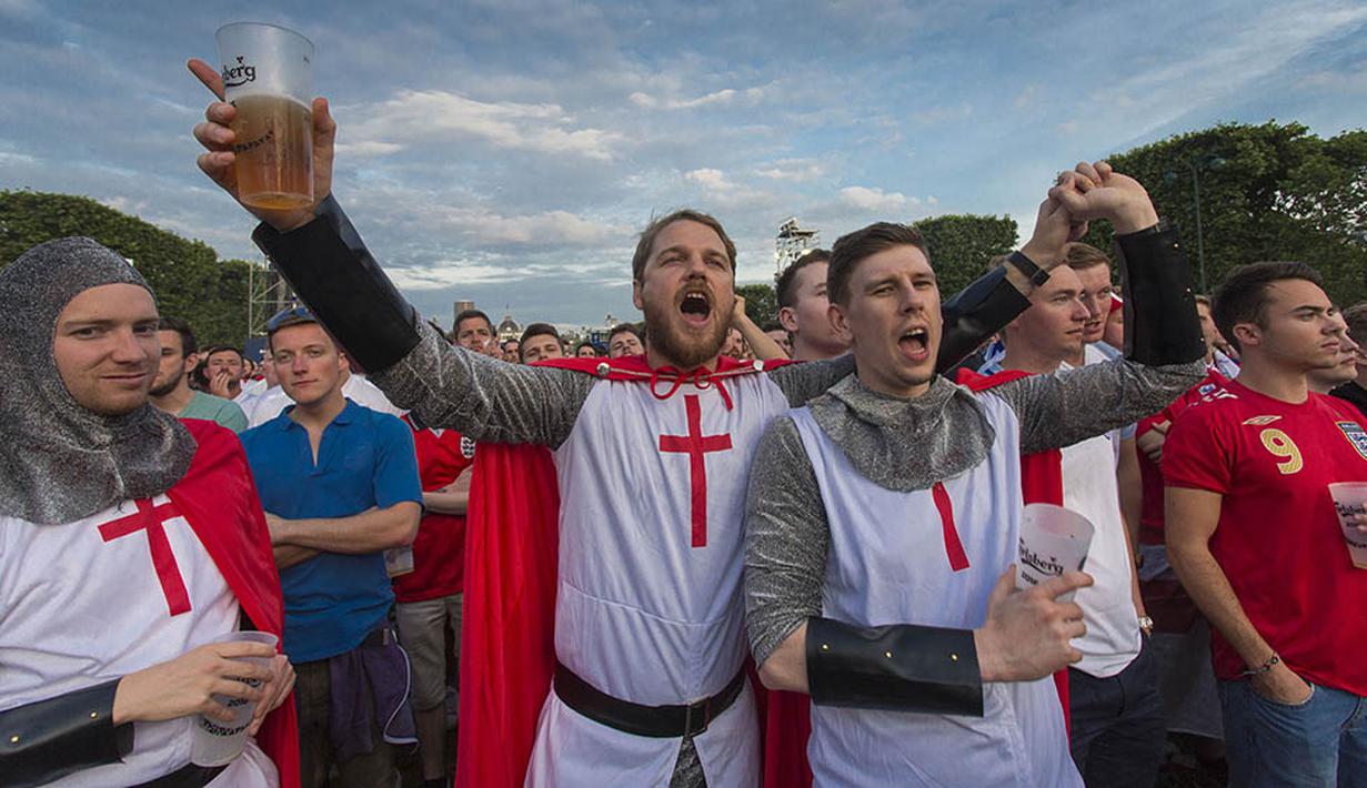 Menggunakan baju tradisional Inggris suporter menyaksikan laga Grup B Piala Eropa 2016 antara Inggris melawan Rusia di fan zone sekitar Menara Eiffel, Prancis, Sabtu (11/6/2016). (AFP/Geoffroy Van Der Hasselt)
