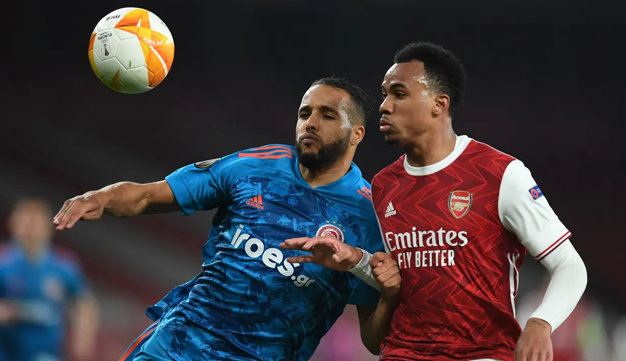 Bek Arsenal, Gabriel (kanan) berebut bola dengan striker Olympiakos, Youssef EL-Arabi dalam laga leg kedua babak 16 besar Liga Europa 2020/2021 di Emirates Stadium, London, Kamis (18/3/2021). Arsenal kalah 0-1 dari Olympiakos. (AFP/Daniel Leal-Olivas)