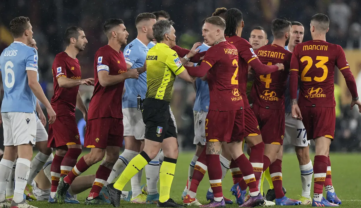 Imbas dari kerasnya laga Derby Roma yang dimenangkan AS Roma dengan skor 3-0 atas Lazio (20/3/2022) membuat pertandingan sempat dihentikan di menit ke-54 akibat pelanggaran Gianluca Mancini yang menyikut Luis Alberto. Para pemain sempat saling dorong dan adu argumen. (AP/Andrew Medichini)
