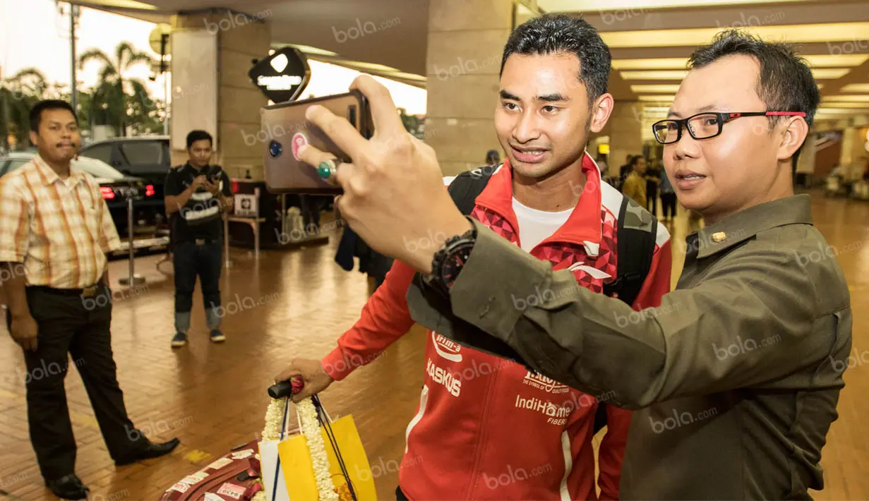 Pebulutangkis tim Piala Thomas Indonesia, Tommy Sugiarto, selfie bersama warga saat tiba di Bandara Soekarno-Hatta. Meski lelah para pebulutangkis Indonesia tetap ramah menyapa para warga di Bandara. (Bola.com/Vitalis Yogi Trisna)