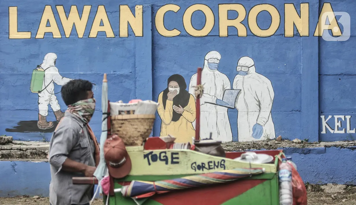 Pedagang kaki lima melintasi mural bertemakan Imbauan Protokol Kesehatan Covid-19 di kawasan Bukit Duri, Jakarta, Minggu (25/10/2020). Gubernur DKI Anies Baswedan kembali memperpanjang Pembatasan Sosial Berskala Besar (PSBB) masa transisi hingga 8 November 2020. (merdeka.com/Iqbal Nugroho)