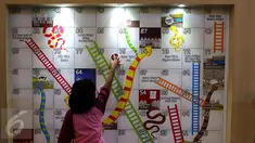 Seorang anak tengah bermain di wahana ular tangga di Kota Kasablanka, Jakarta (12/11). Pengunjung diajak bermain dan berpetualang di area 150 Years Nestle Story. (Liputan6.com/Fery Pradolo)