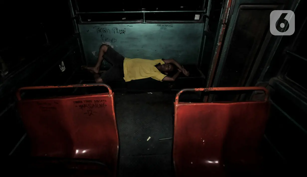 Beni (40), sopir Metromini 03 tidur di dalam bus saat menginap di pool. Karya foto ini sedang dipamerkan dalam pameran foto dengan tema ”Innovation” di Erasmus Huis. (merdeka.com/Iqbal S Nugroho)