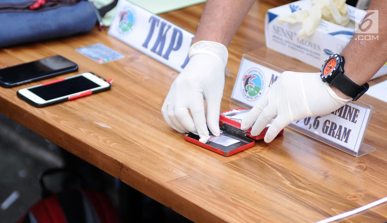 Polisi menunjukkan barang bukti penangkapan artis peran dan model, Jennifer Dunn oleh satuan Dirnarkoba Polda Metro Jaya, Jakarta, Selasa (2/1). Polisi menyita 0,6 gram sabu dan sejumlah telepon genggam. (Liputan6.com/Helmi Fithriansyah)