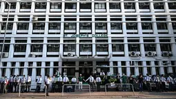 Para siswa, alumni dan guru saling memegang tangan di area Mid-Levels, Hong Kong, Senin (9/9/2019). Aksi dilakukan para siswa yang masih berseragam sekolah sambil memakai masker sebagai bentuk dukungan terhadap demonstran anti pemerintah setelah bentrokan pada akhir pekan. (Anthony WALLACE/AFP)