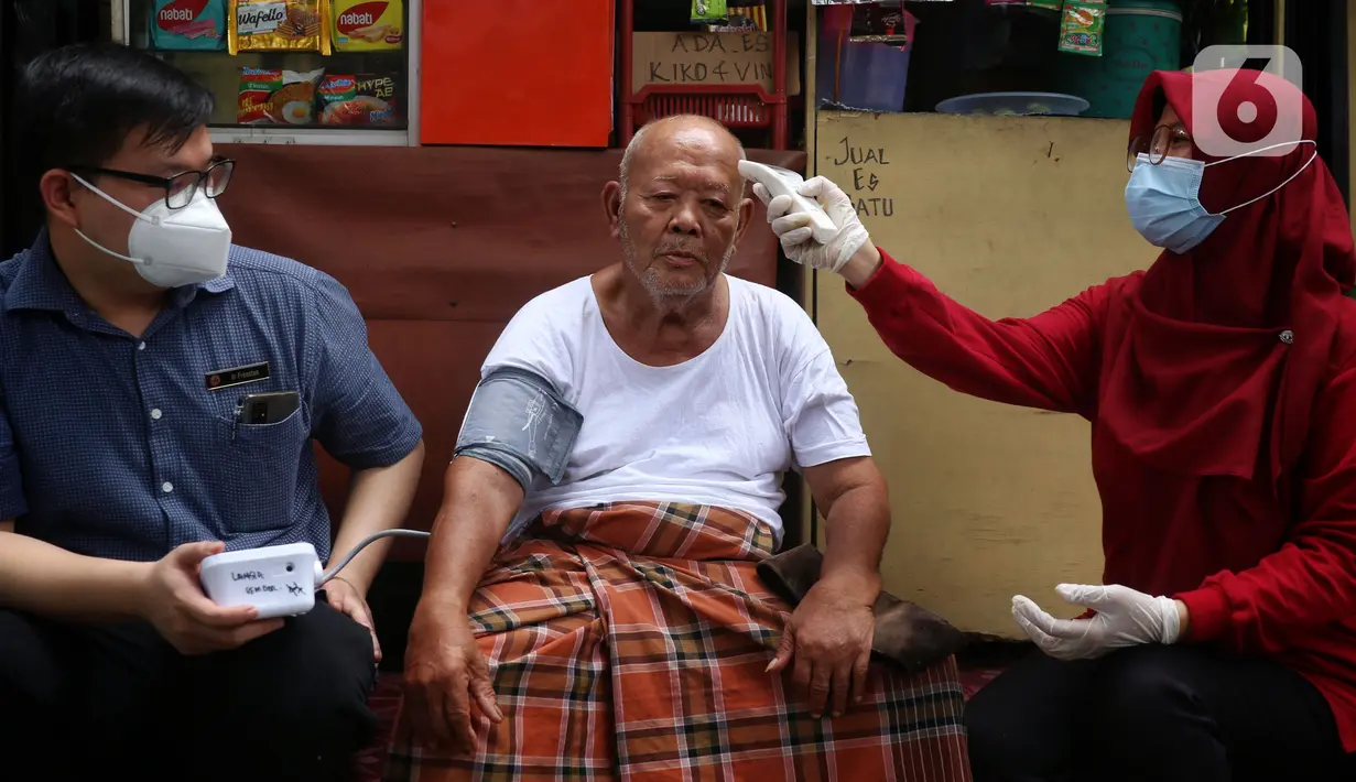 Petugas Puskesmas Gembor memeriksa suhu tubuh ODGJ sebelum melakukan vaksinasi Covid-19 dengan mendatangi langsung dari rumah kerumah di kecamatan Priuk, Kota Tangerang, Selasa (8/6/2021). Vaksinasi diberikan untuk memberikan kekebalan tubuh agar terhindar dari Covid-19. (Liputan6.com/Angga Yuniar)