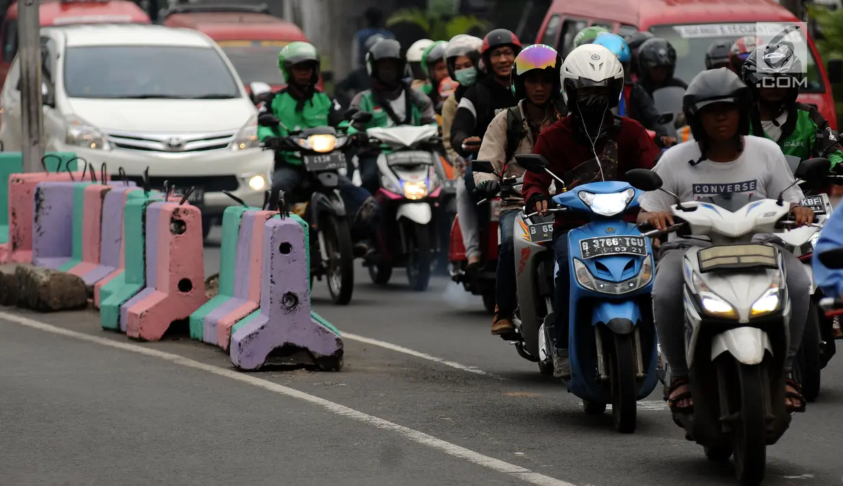Pengendara melintasi Jalan TB Simatupang, Jakarta, Jumat (7/7). Jalan TB Simatupang sekitar perempatan Pasar Rebo menjadi berwarna dengan tampilan pot cat dan pembatas jalan warna warni. (Liputan6.com/Helmi Fithriansyah)